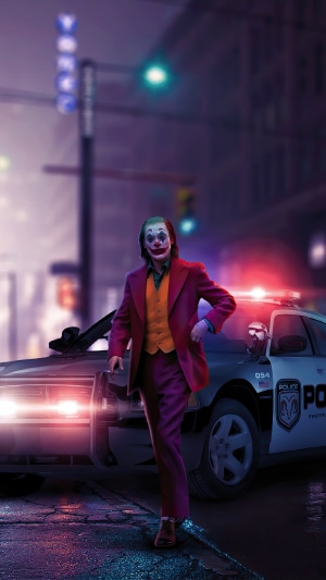 Joker standing next to a police car