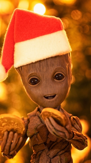Baby Groot wearing a Santa hat holding coins