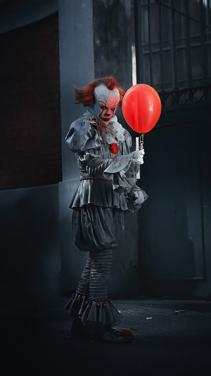 Pennywise the Dancing Clown from IT holding a red balloon