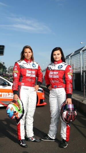 Two female race car drivers with helmets