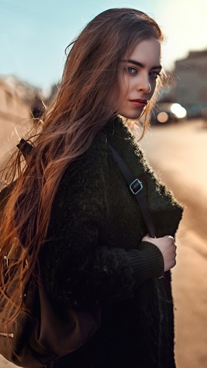 Girl with long brown hair wearing a green coat