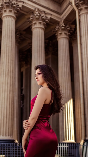 Woman in red dress in front of columns