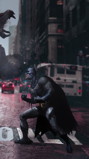 Batman in a city street with a monster