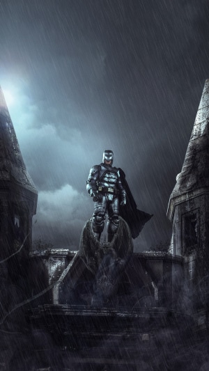 Batman standing on a gargoyle in the rain