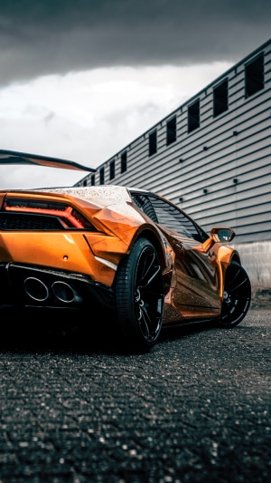 Orange Lamborghini Huracan parked near a building