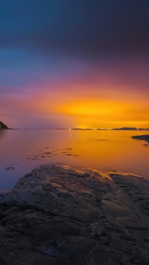 Sunset over the ocean with rocky shore