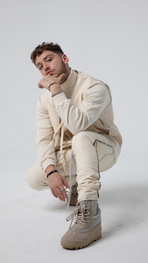 Singer Bazzi crouching in a studio 4K