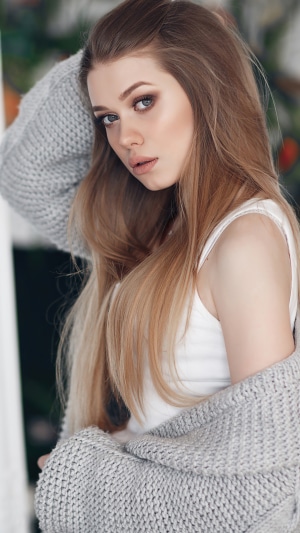 Young woman with blonde hair wearing a grey cardigan
