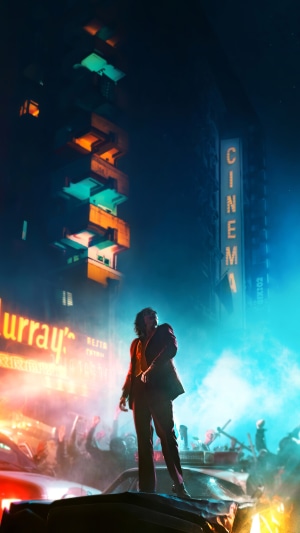 Joker standing on cars in a city at night