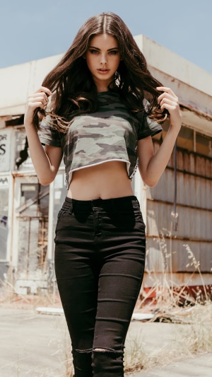 Meika Woollard in camouflage crop top and black jeans