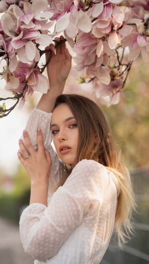 Model posing under blooming magnolia tree
