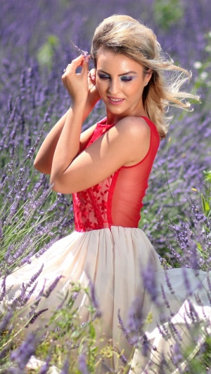 Model in a red and cream dress in a lavender field