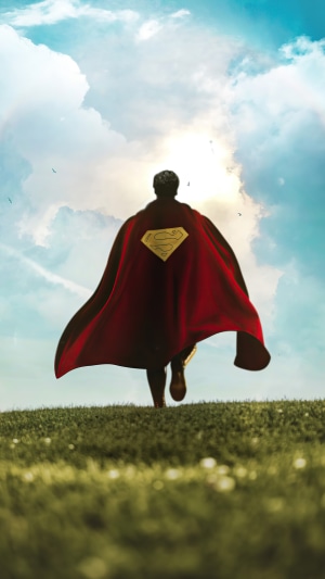 Superman running on a grassy hill with clouds