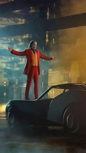 Joker standing on a car in a city