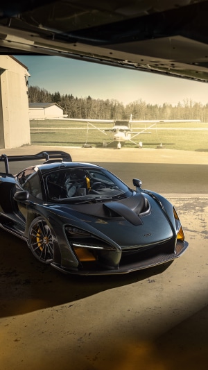 McLaren Senna in a hangar with a small airplane