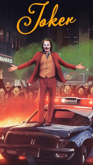 Joker standing on a police car with a crowd