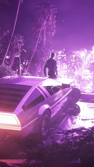 Man sitting on a DeLorean car at night