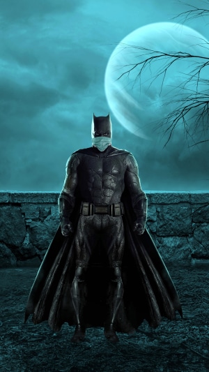 Batman wearing a mask in front of the moon