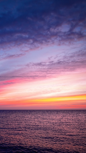 Ocean at sunrise with colorful clouds