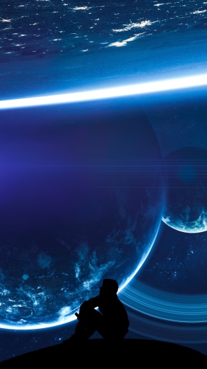 Silhouette of a person looking at a ringed planet in space
