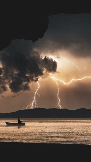Fisherman in a boat during a lightning storm