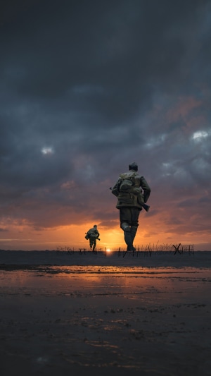 Soldiers running on a beach at sunset