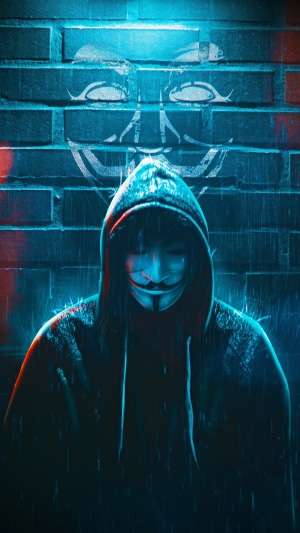 Anonymous mask figure in front of brick wall with symbol