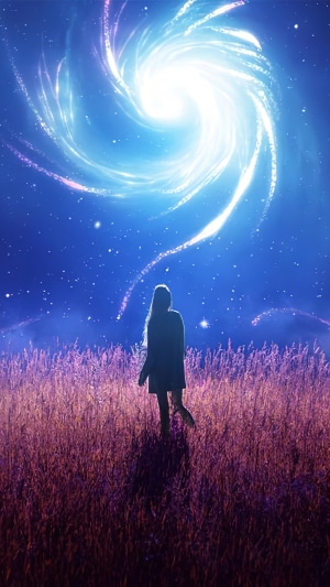 Girl in a field looking at a swirling galaxy