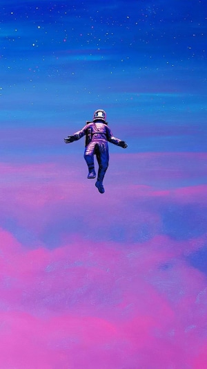 Astronaut floating in a colorful sky
