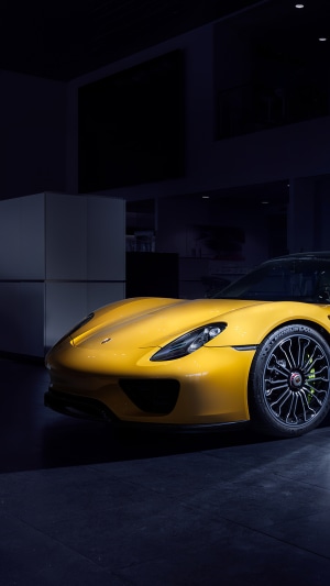 Yellow Porsche 918 in a dark garage