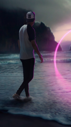 Man walking on beach with neon circle