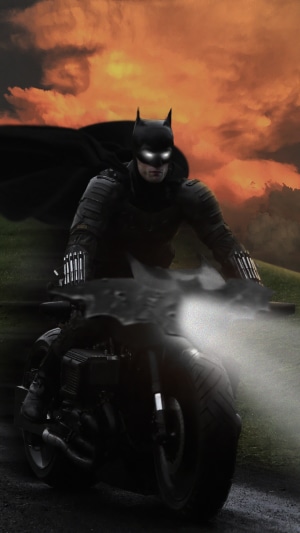 Batman riding a motorcycle at sunset