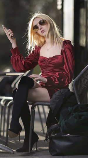 Blonde woman in red dress holding phone