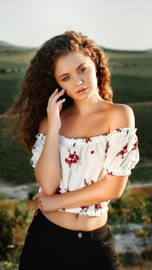 Young woman with curly hair in a floral top
