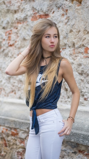 Young blonde woman in Nike tank top and white jeans