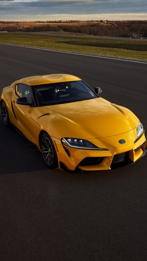 Yellow Toyota GR Supra on a racetrack
