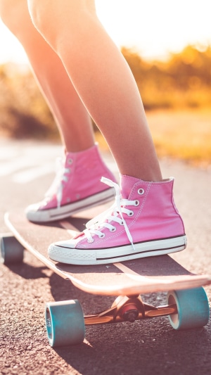 Girl in pink sneakers on a skateboard