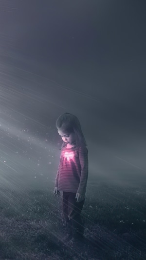 Girl with glowing heart in a field