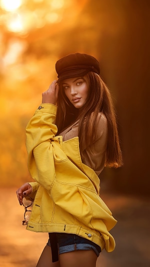Model wearing yellow jacket and black cap