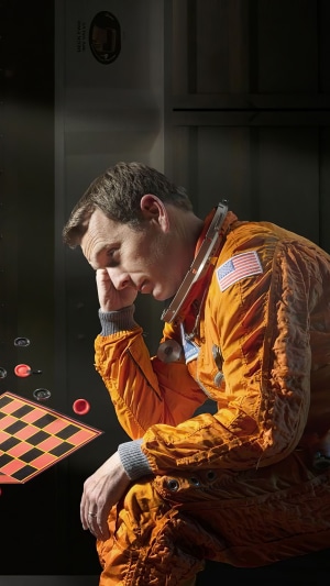 Astronaut in orange suit looking down
