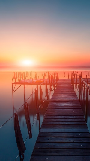 Wooden pier at sunset over calm water