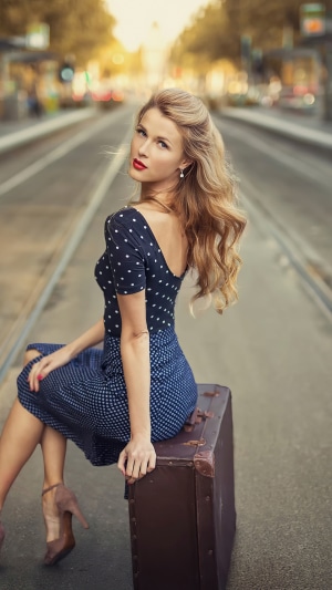 Woman in polka dot dress with suitcase