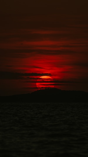 Sunset over the ocean with a mountain silhouette