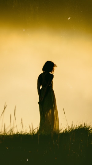 Girl in a dress standing in tall grass