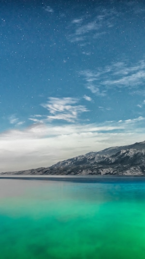 Mountains and sea under a starry sky