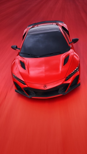 Red Acura NSX sports car in motion