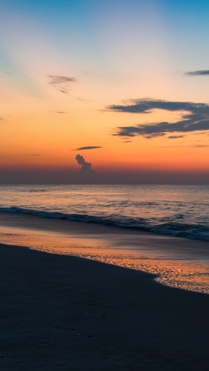 Beach sunrise with colorful sky and ocean waves