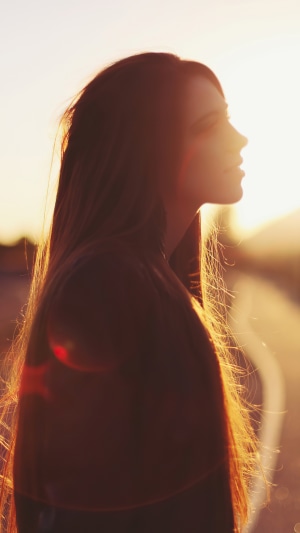 Silhouette of a woman with long hair at sunset