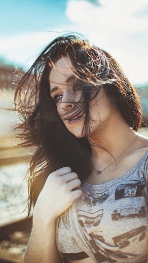 Girl with windblown hair and boombox shirt