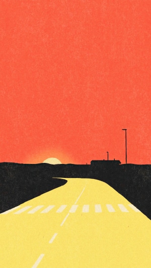 Road at sunset with buildings and a streetlight